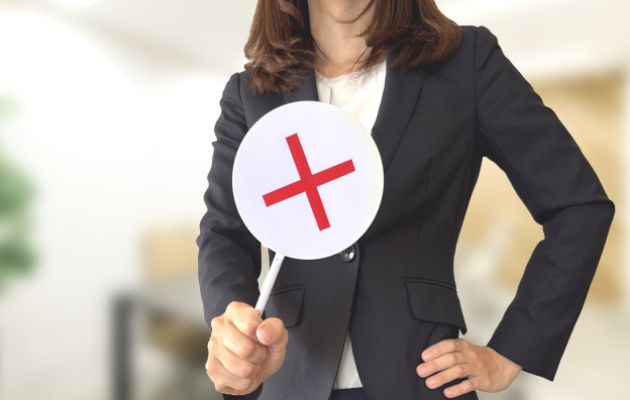 放っておかないと言う場面を女性がバツのプラグを持って胸元で差し出している様子の写真
