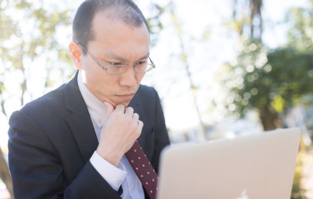 男性が外部委託をパソコンで探している様子の写真