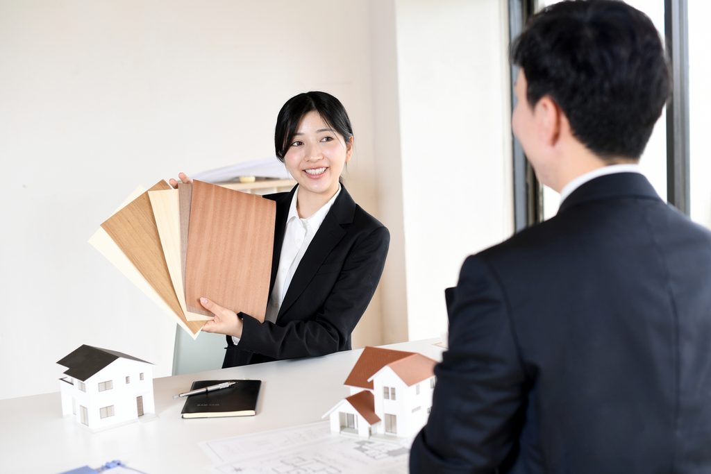 床材を説明する女性と床材を選ぶ男性の画像