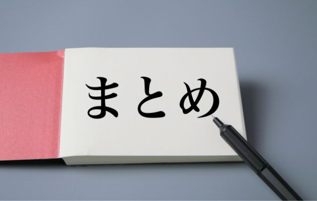 棒グラフや円グラフの資料の上に木のブロックに「まとめ」と書いてある写真