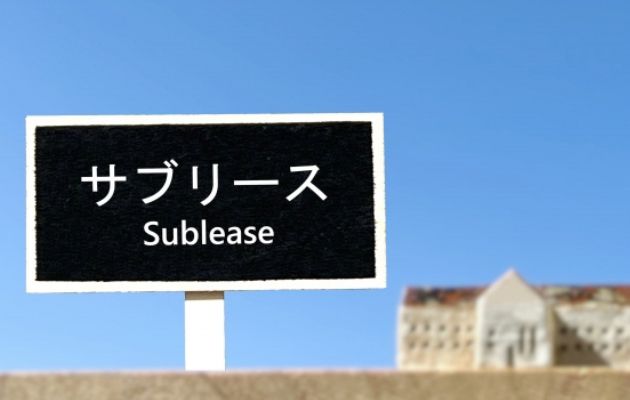 建物の背景に立ち札で「サブリース」と書いてある写真
