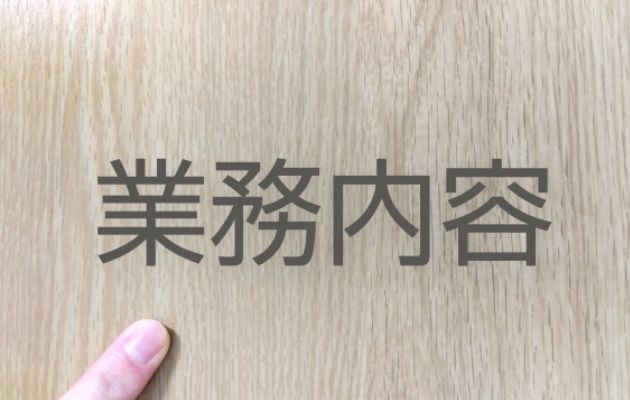 木の背景に「業務内容」と書かれている写真