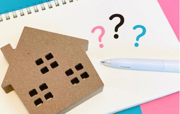 ノートの上にコルクの家がおいてあり、？マークとボールペンが置いてある写真