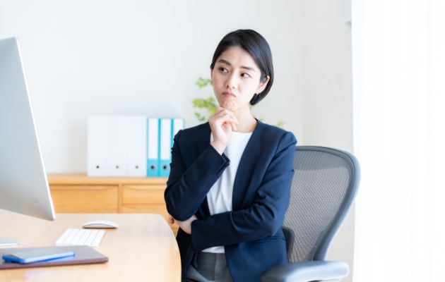 ディスクで顎に手を添えて、違いを考えている女性の写真