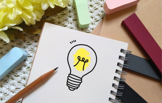 ノートに電球の絵が書いてある。えんびつやノート、付箋が周りに置いてあり、電球のひらめきで選び方を表している写真