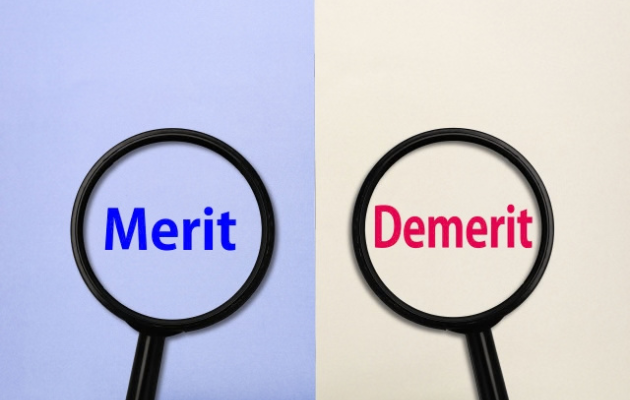 左に「Merit」右に「Demerit」と書かれており、虫眼鏡が文字の上に置いてある写真