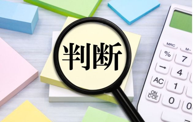 黄色の付箋に判断と書かれており、虫眼鏡が置いてある写真。
周りに付箋と電卓が置いてある。