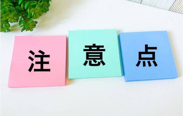 ピンクとエメラルドグリーン、淡い青の付箋に「注意点」と書かれている写真